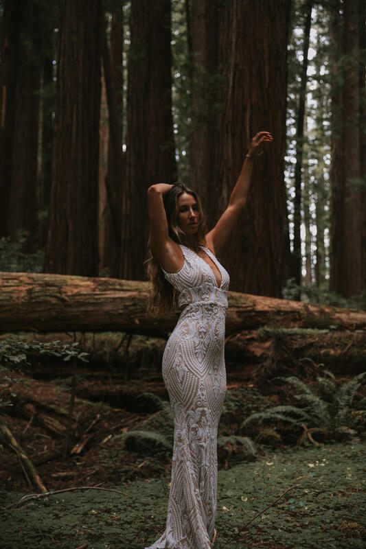 Full-length bridal portrait dwarfed by towering redwood trees