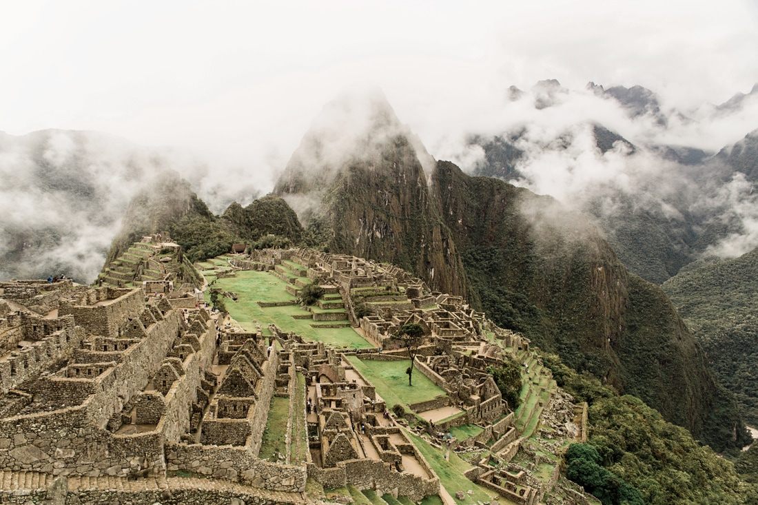 Misty view of the Machu Picchu ruins emerging through rainy-season clouds
