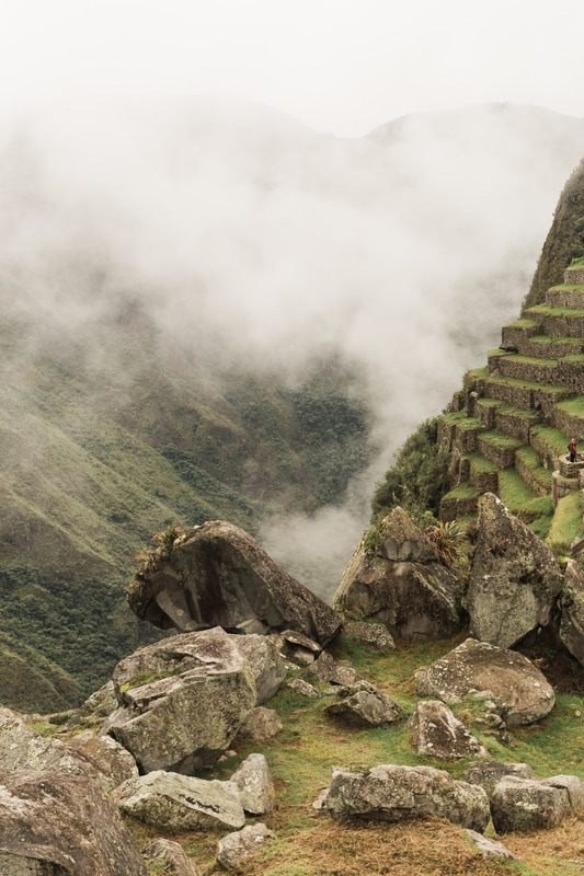 A hazy, cloud-wrapped view of Machu Picchu's iconic ruins