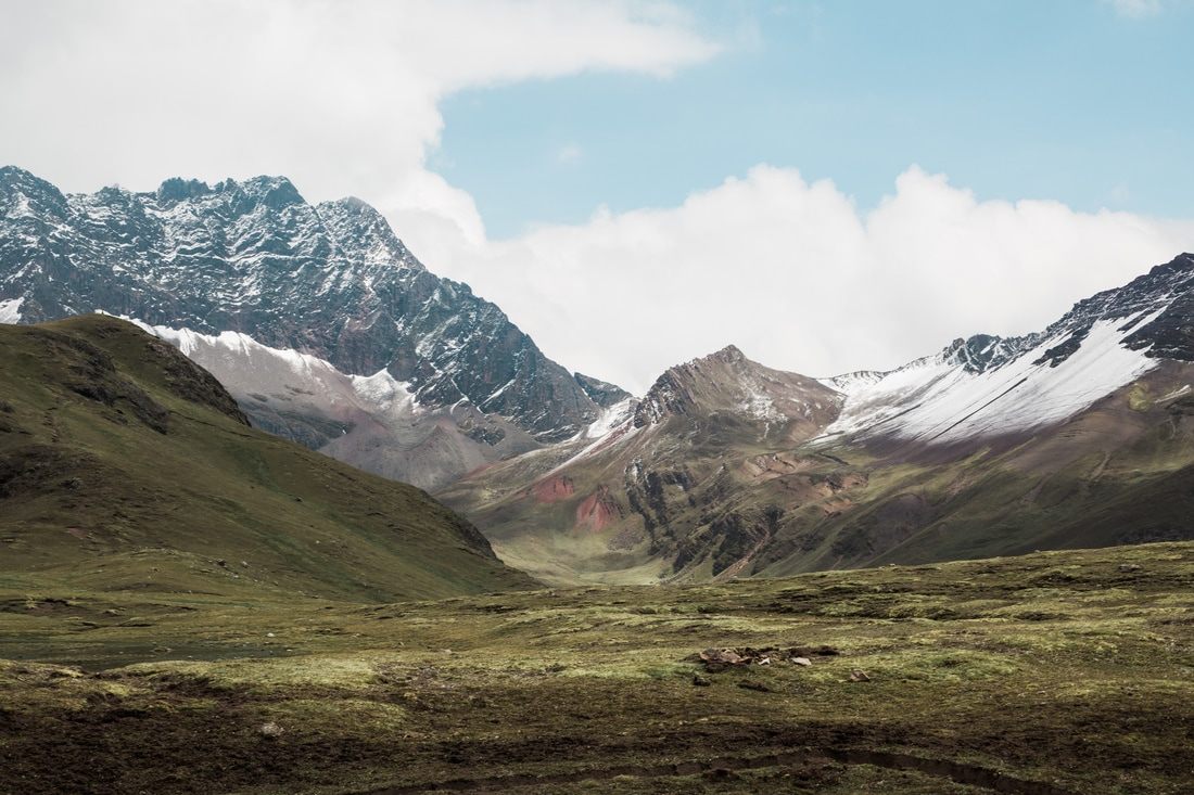 Rugged mountain trail with snow-capped peaks near Vinicunca, Peru