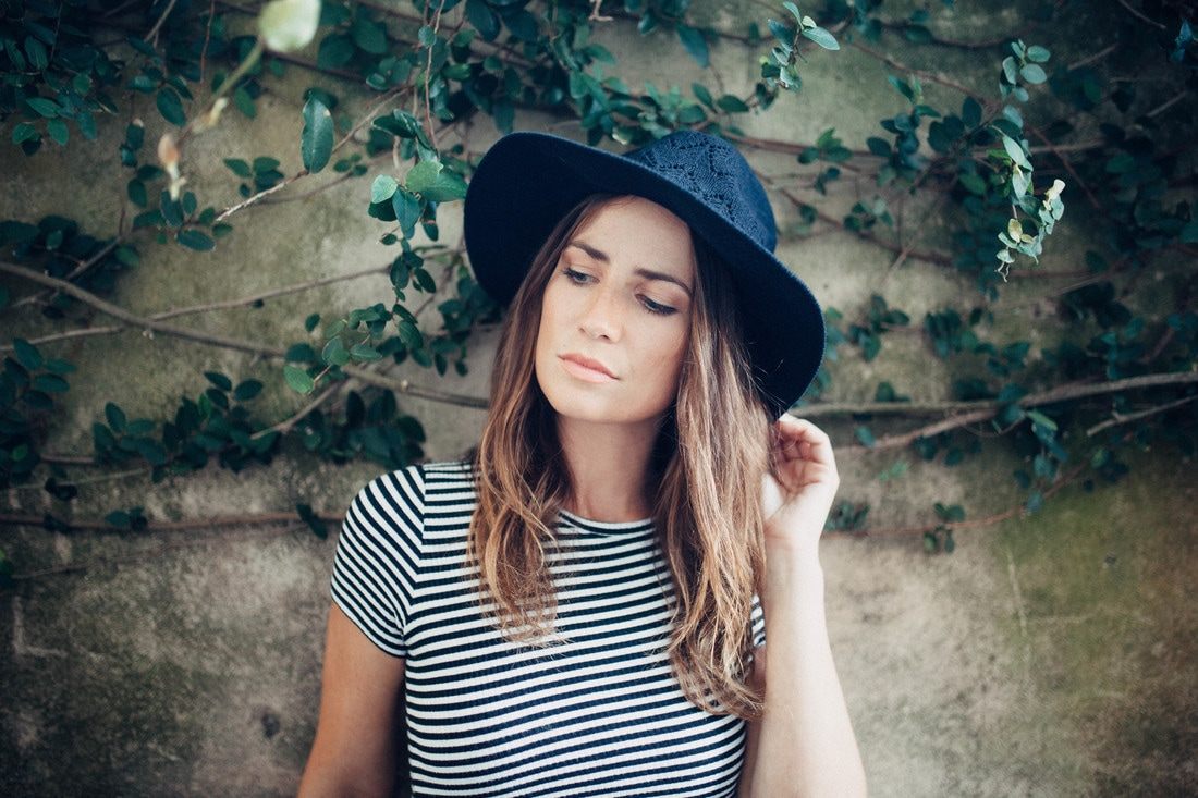 Susan posing against a brick wall in a downtown Charleston alley