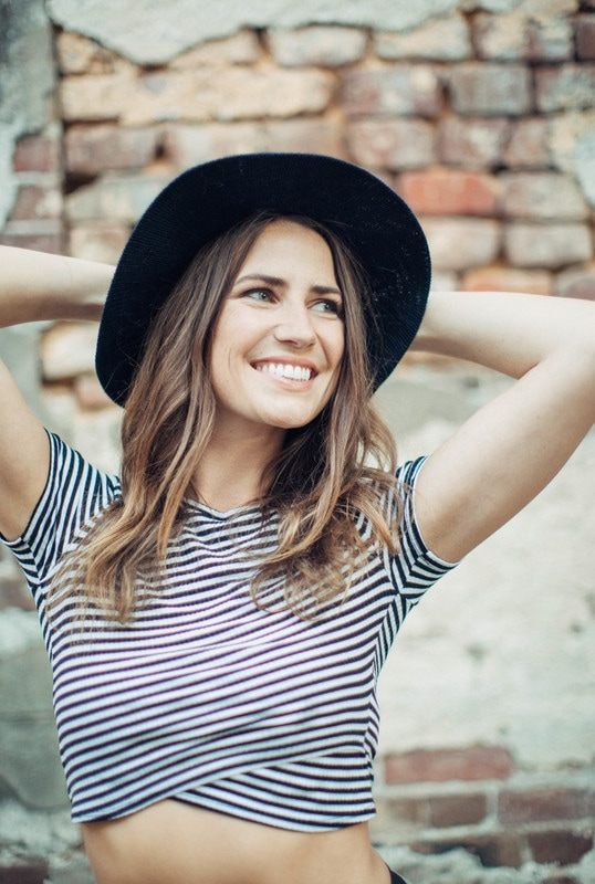 Susan posing against a brick wall in a downtown Charleston alley