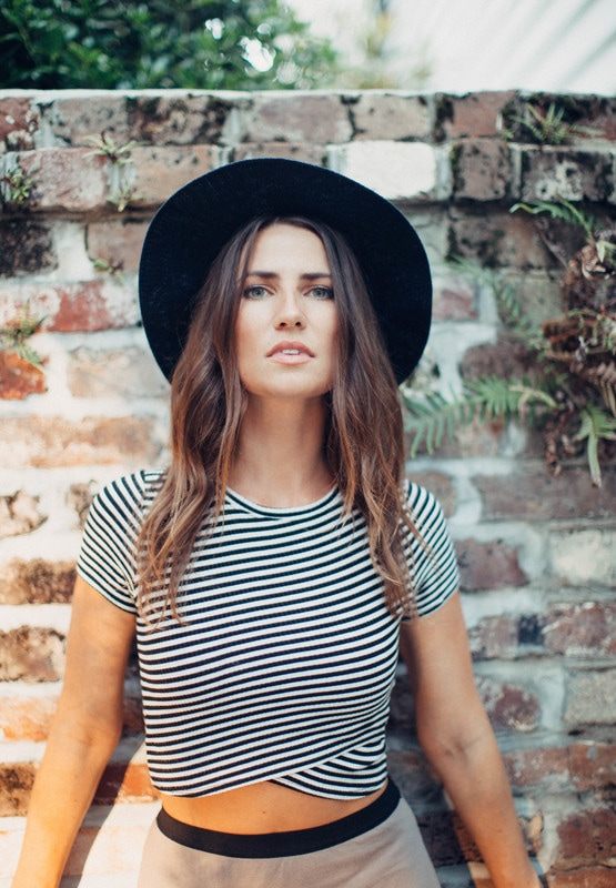 Susan posing against a brick wall in a downtown Charleston alley