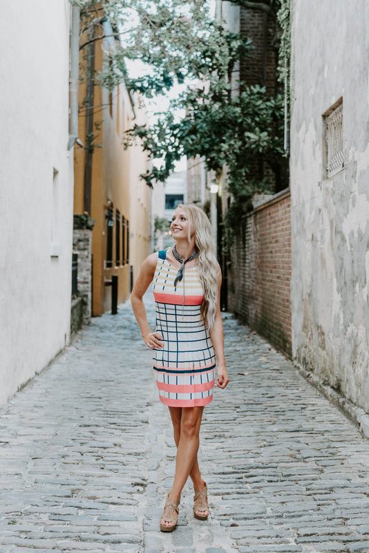 Portrait of Lindsey O leaning against a wrought-iron gate in downtown Charleston