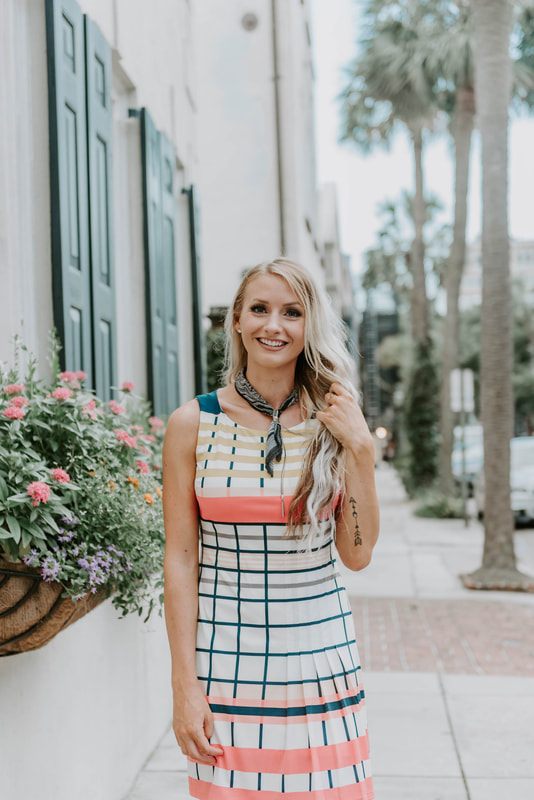 Charleston portrait session showing Lindsey O walking past historic pastel row houses