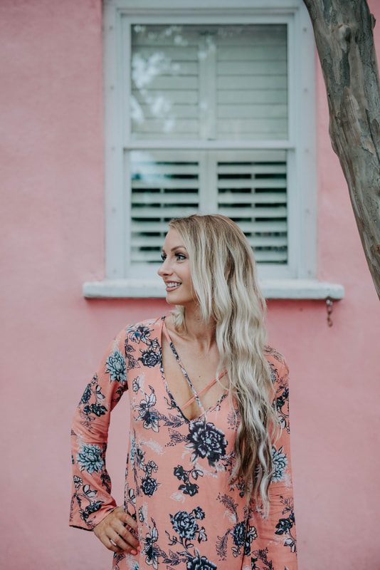 Full-length portrait of Lindsey O in front of a Charleston courtyard entrance