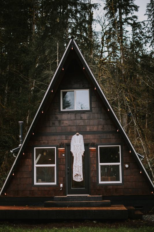Detail shot of Tanya's antique-style ivory wedding gown against dark trees.