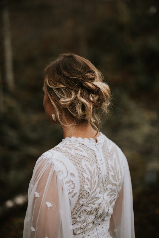 Wide landscape shot of the ivory gown against the dark PNW forest.