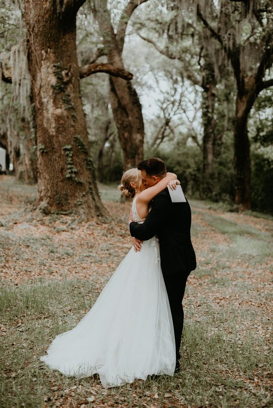 Alexis and Max embracing warmly in front of the Johns Island barn venue