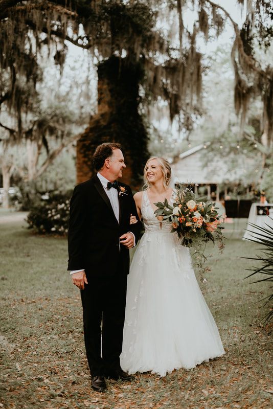 Alexis embracing warmly beneath oak trees draped in Spanish moss