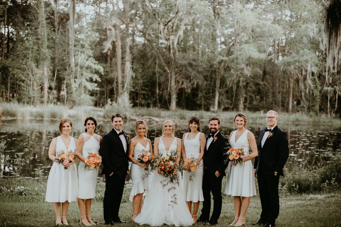 The bride and groom celebrating with friends and family in front of the Johns Island barn venue