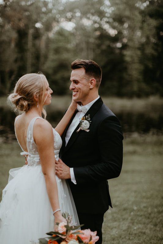 The newlyweds posing for portraits surrounded by garden greenery