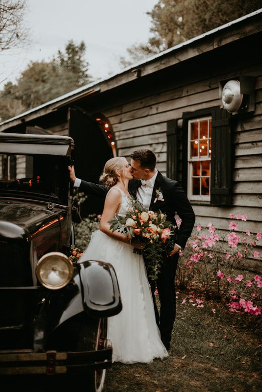 The bride and groom laughing together beneath oak trees draped in Spanish moss