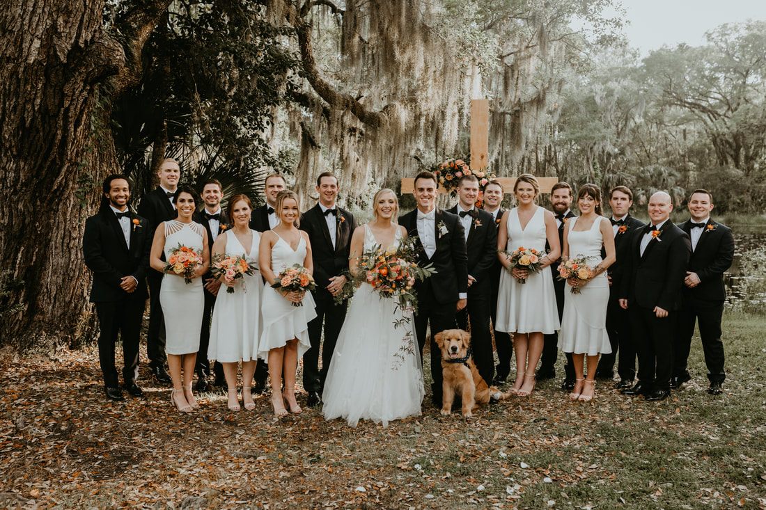Alexis and Max posing for portraits beneath oak trees draped in Spanish moss