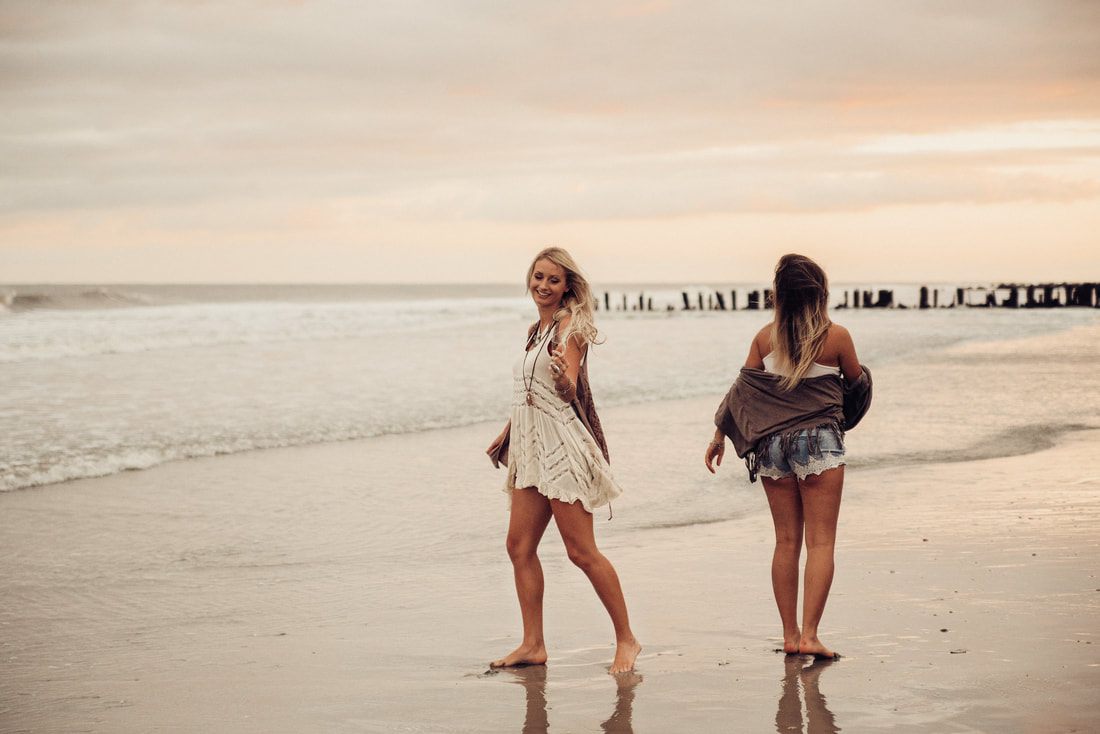 Two best friends posing together on Folly Beach, South Carolina