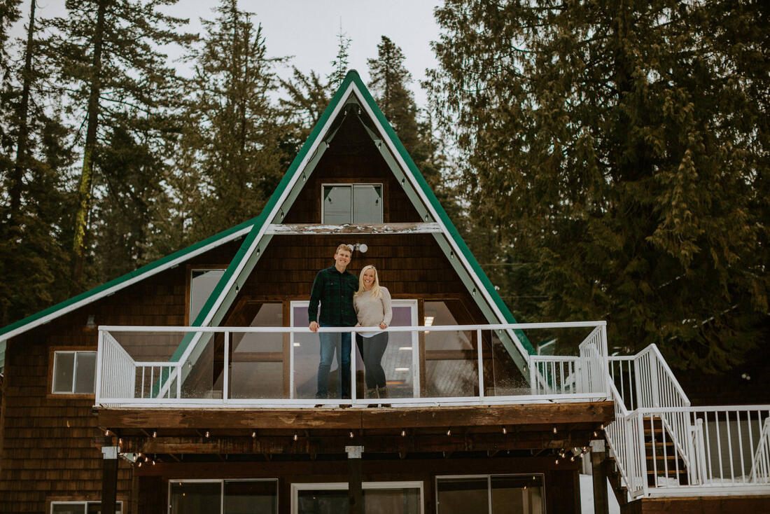 Couple standing together outside their a-frame cabin near Lake Wenatchee, Washington