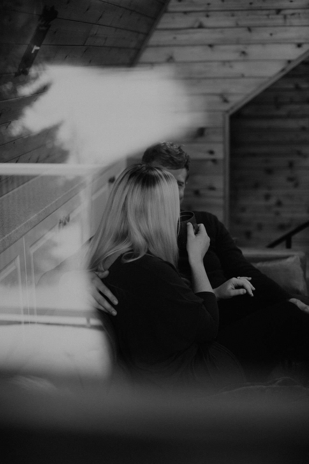 Couple standing close together near tall evergreen trees