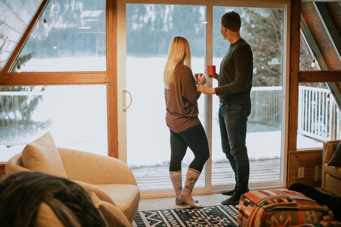 Couple walking along a wooded path near their PNW cabin