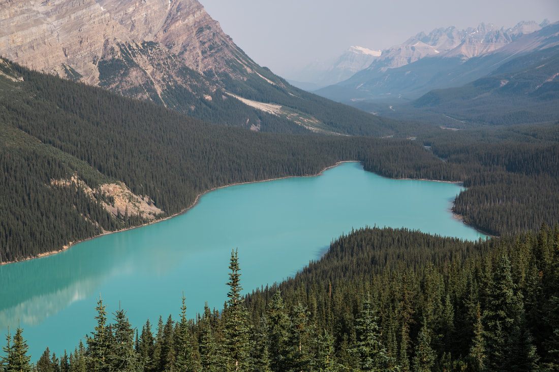 Crystal clear blue lake reflecting the peaks of the Canadian Rockies