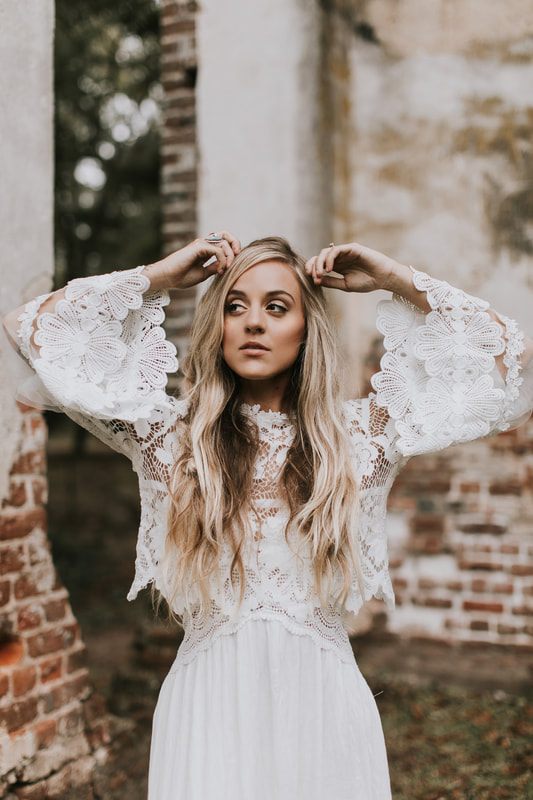 Bohemian bride holding a bouquet of succulents and cacti among the Sheldon Church Ruins near Charleston.