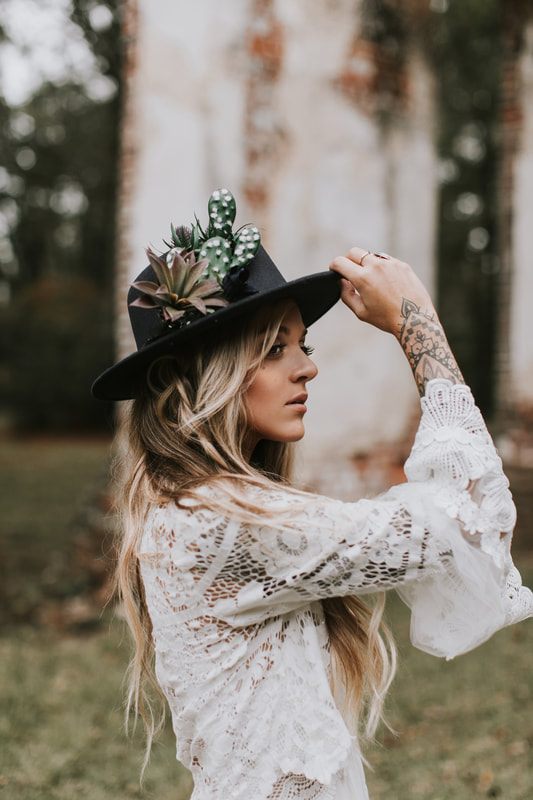 Charleston bride in a bohemian floral crown standing amid historic ruins architecture.