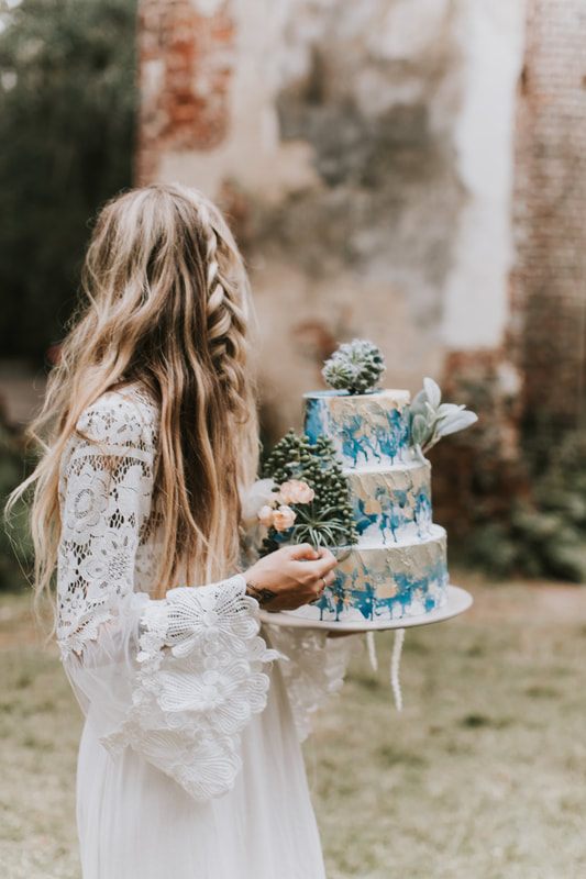 Bohemian bride holding a bouquet of succulents and cacti among the Sheldon Church Ruins near Charleston.