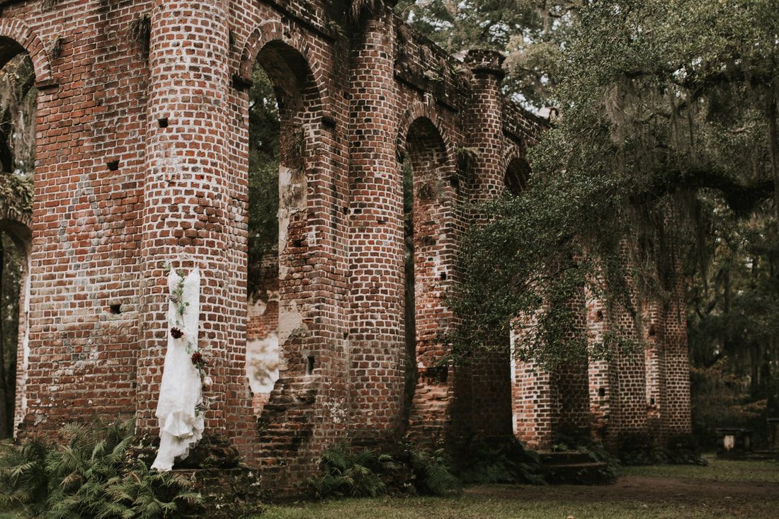 Bride posing among moss-draped oaks and crumbling columns at the Sheldon Church Ruins.