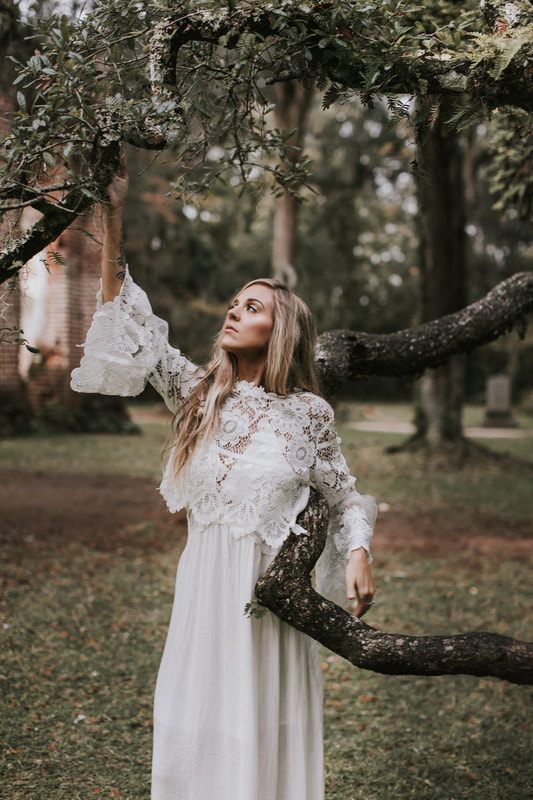 Bohemian bride holding a bouquet of succulents and cacti among the Sheldon Church Ruins near Charleston.