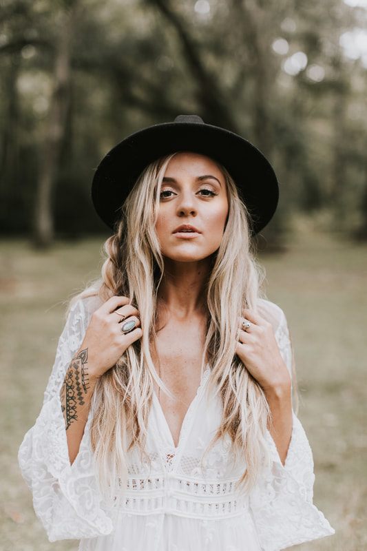 Charleston bride in a bohemian floral crown standing amid historic ruins architecture.