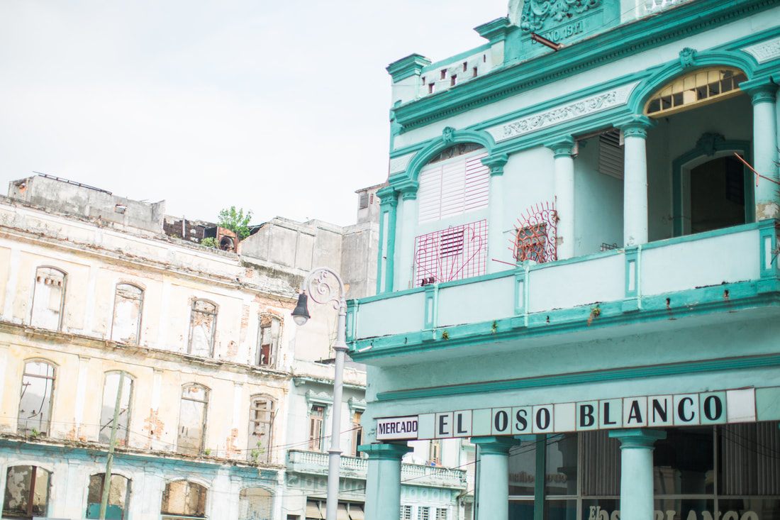 Vintage car parked beside a weathered colonial building in Havana