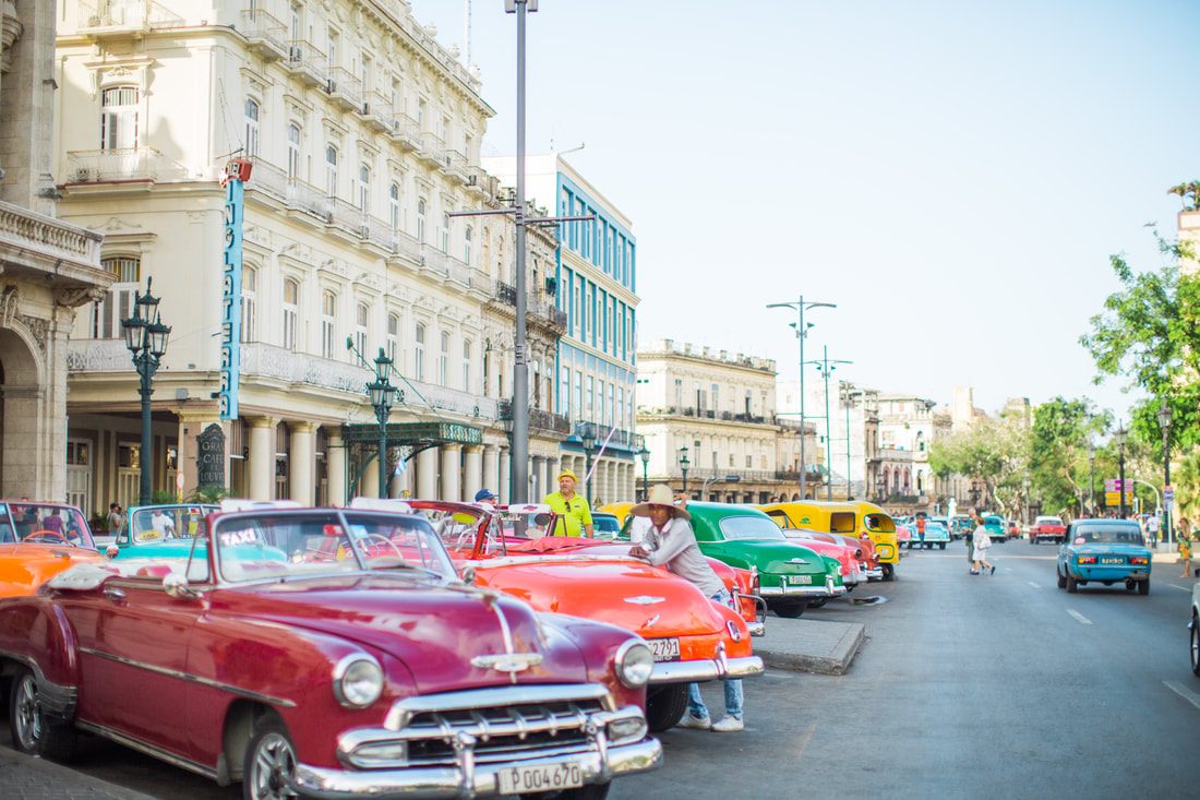 Vintage car parked beside a weathered colonial building in Havana