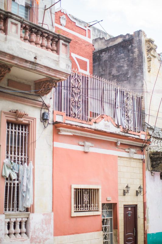 Vintage car parked beside a weathered colonial building in Havana