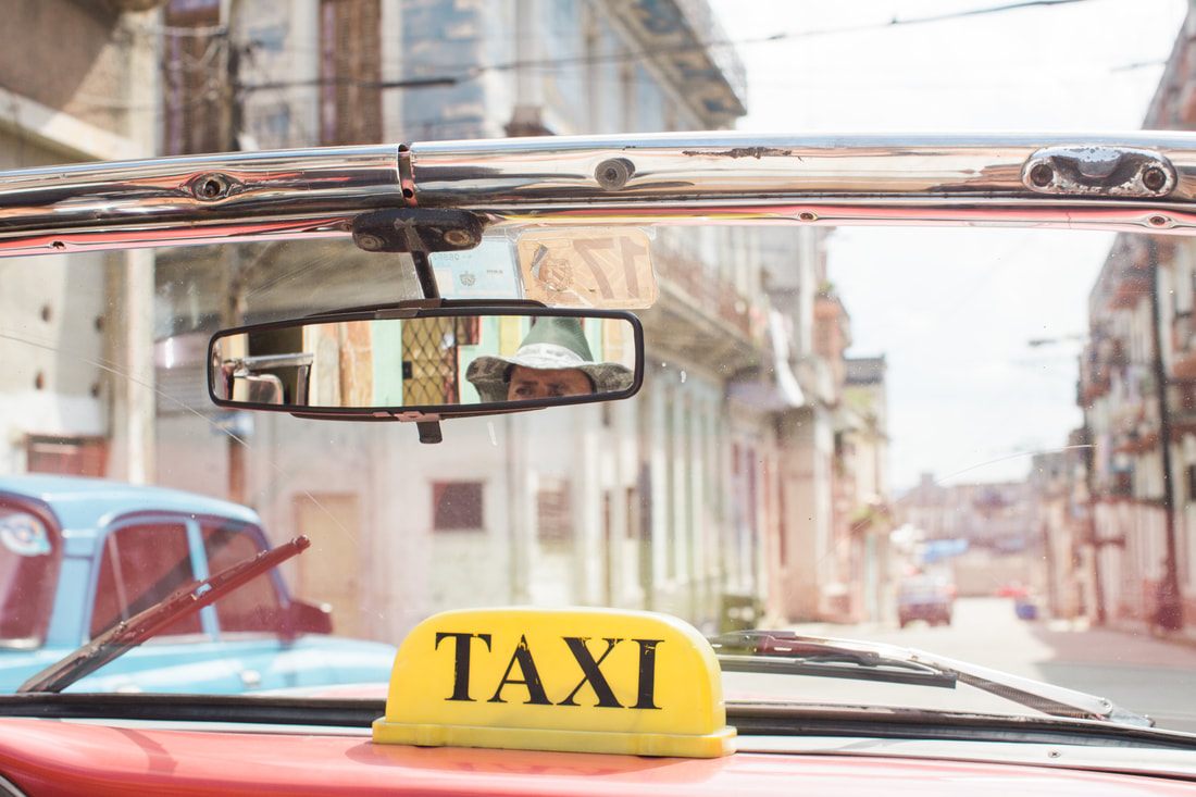 Brightly painted vintage American car parked on a colorful street in Havana, Cuba