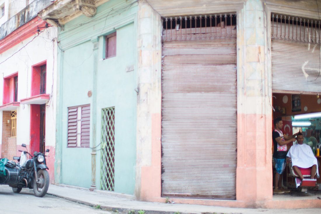 Local life on a narrow cobblestone street in Old Havana, Cuba