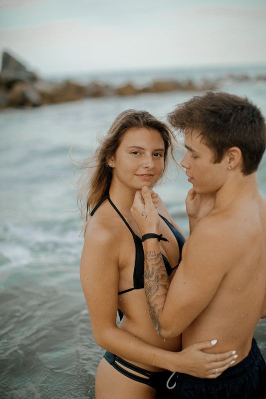 The couple walking along the rocky shoreline along the California coastline
