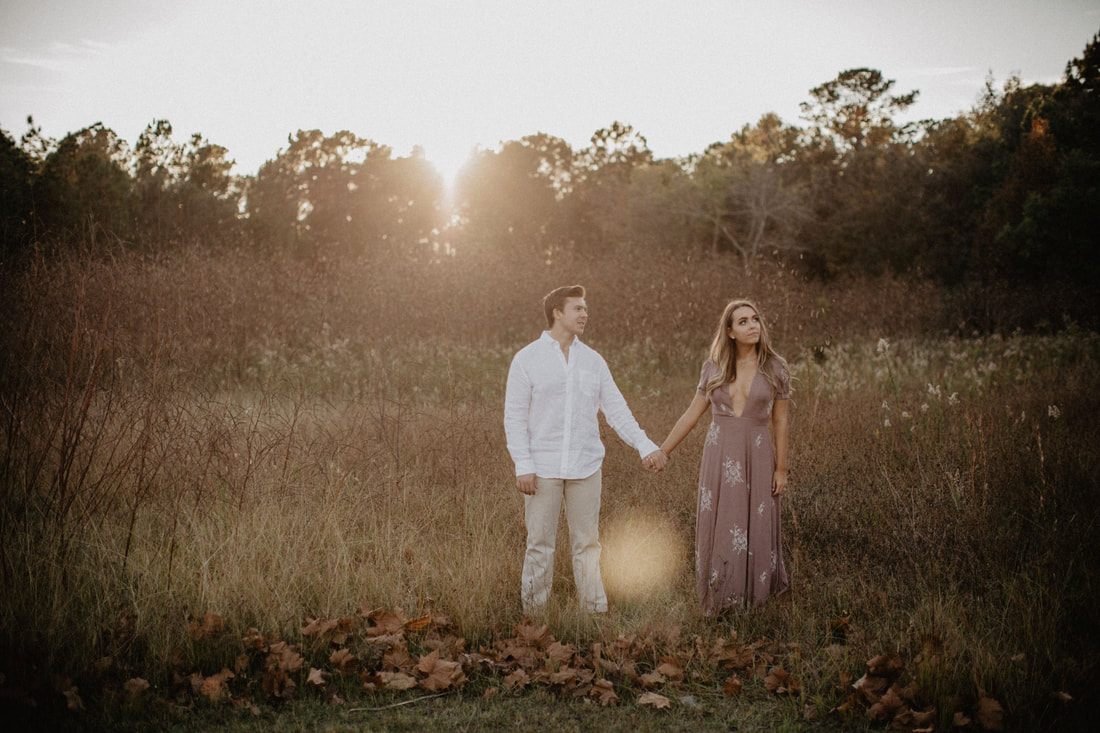 Chase and Mitch walk hand in hand through fields near Charleston, SC.