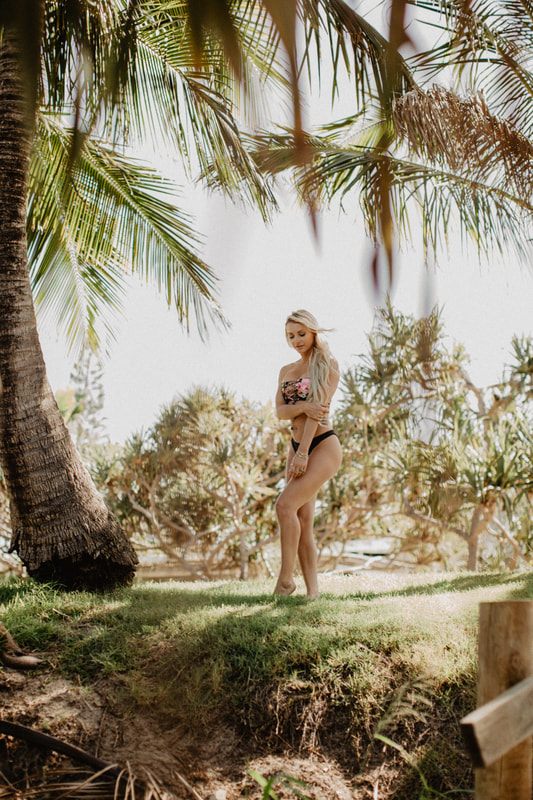 Woman posing in a Cheeky Swim bikini on the beach in Byron Bay, Australia