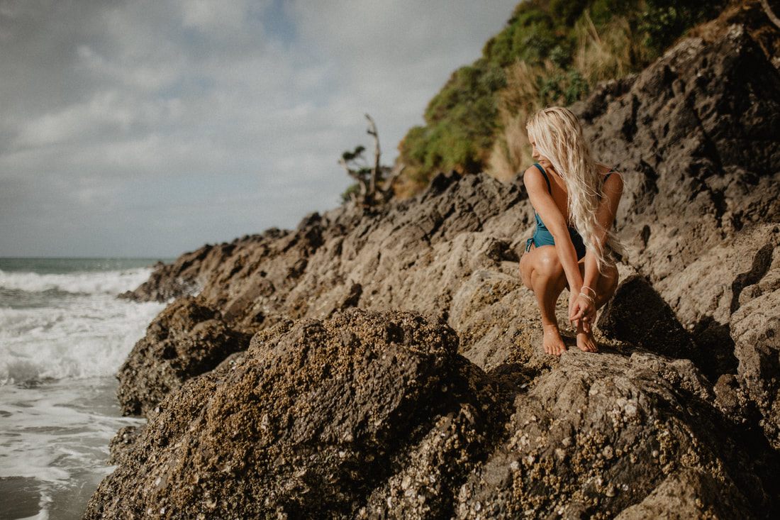 Green hills and ocean views behind a Strange Bikinis swimwear look on Waiheke Island