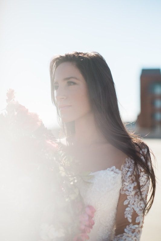 Olivia poses near greenery for a soft, romantic Charleston bridal photo.