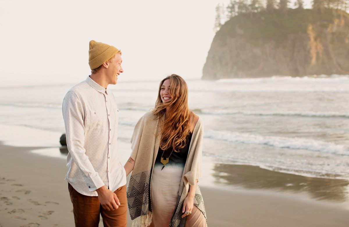 Candid portrait of Zane and Yela laughing together on the rocky coastline of La Push, Washington.