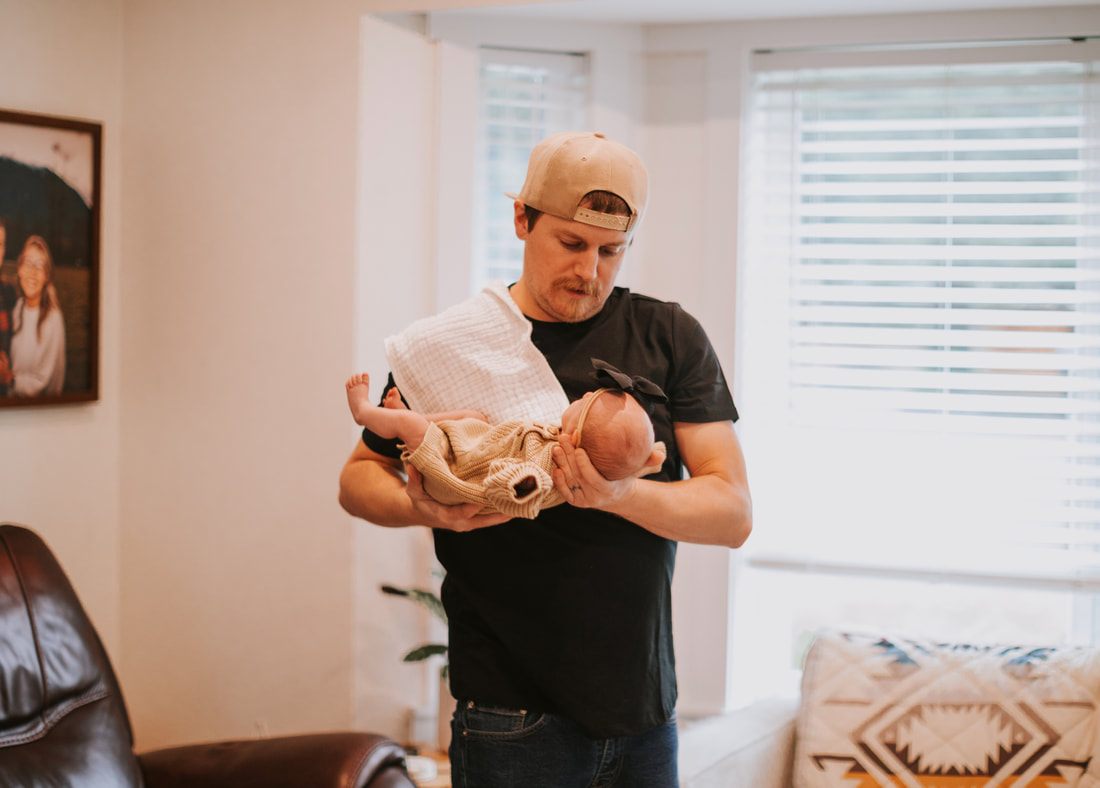 New parents holding their sleeping newborn daughter at home