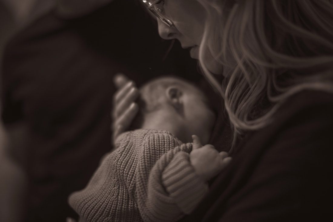 New parents smiling down at their sleeping newborn daughter