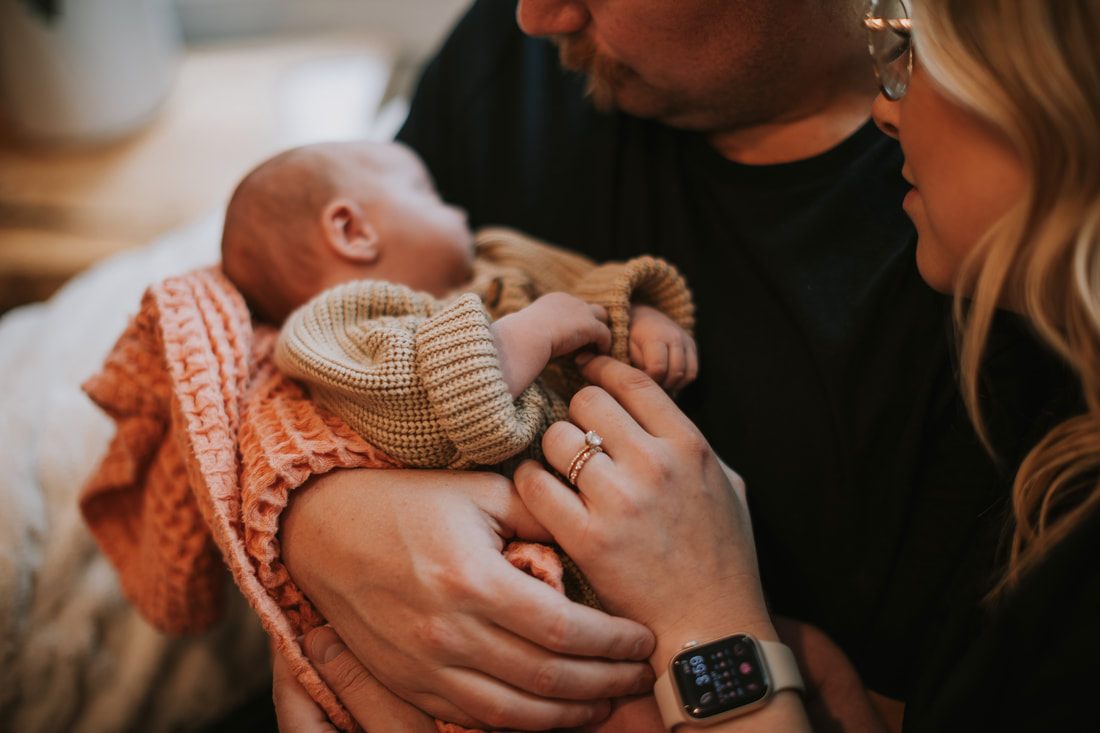 Newborn baby resting on a soft blanket in natural light
