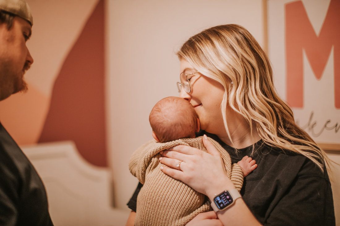 New parents holding their sleeping newborn daughter together