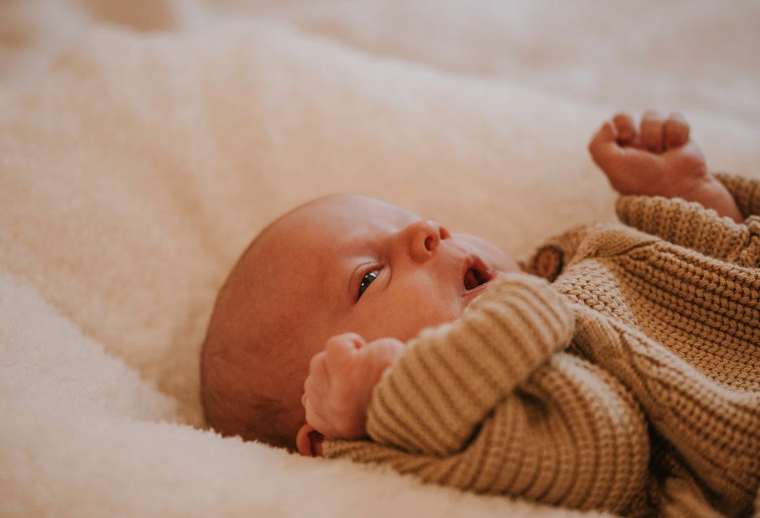 Newborn baby yawning during an in-home photo session