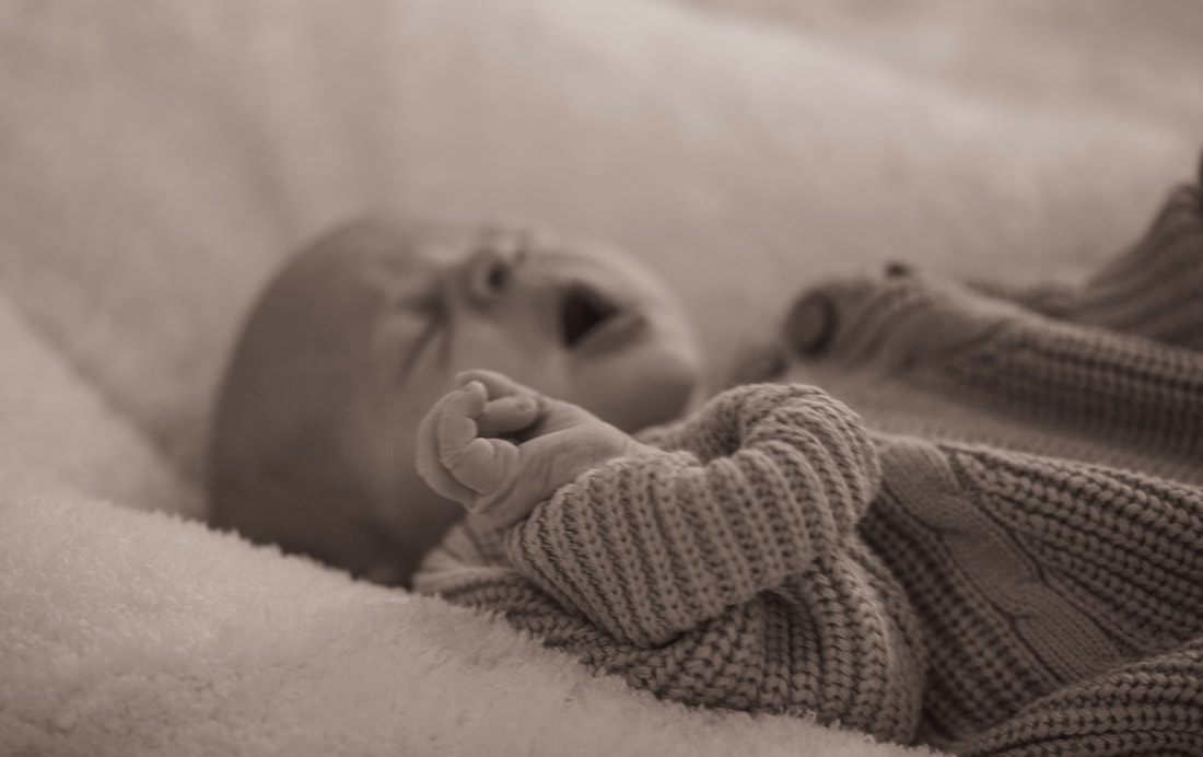 Mother gently cradling her newborn daughter in a quiet moment