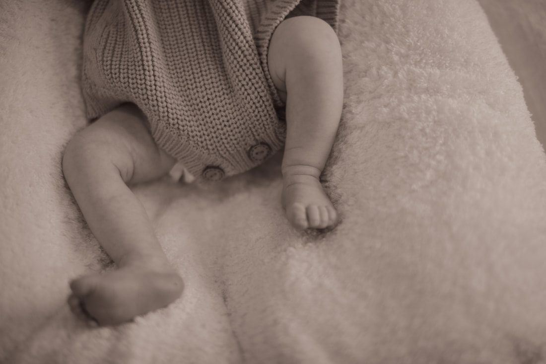 Father holding his newborn daughter near a sunlit window