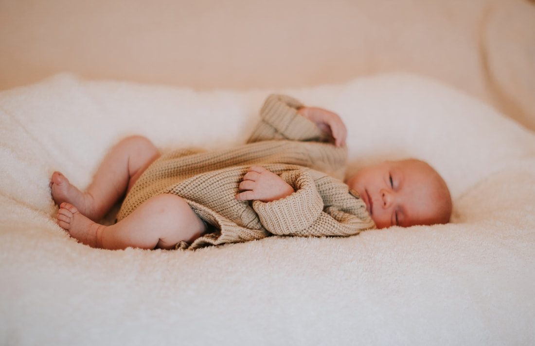 Newborn baby sleeping soundly in a woven nursery basket