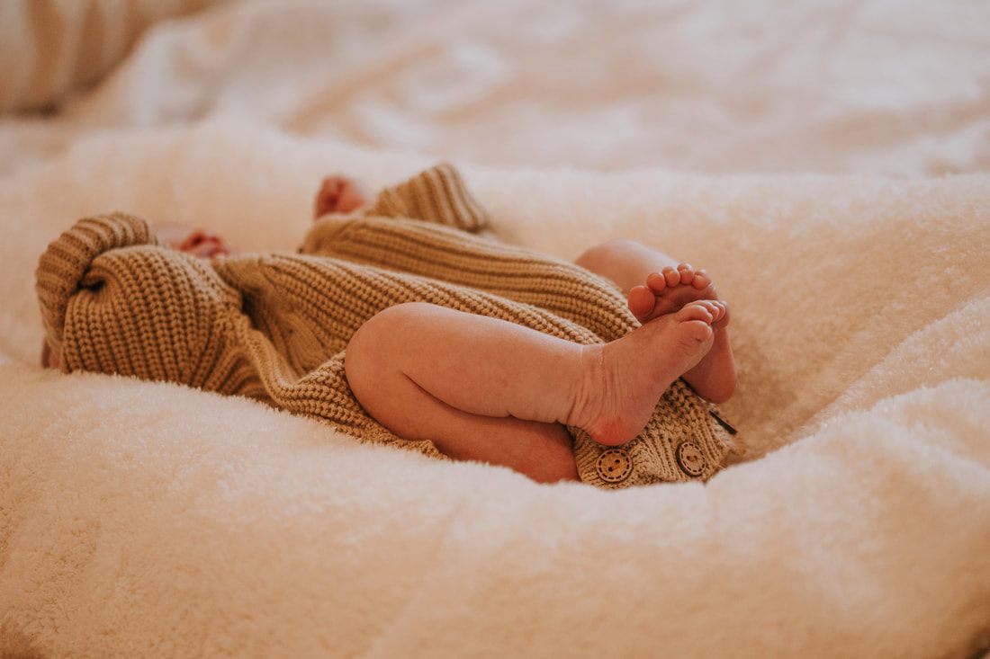 New parents holding their sleeping newborn daughter at home