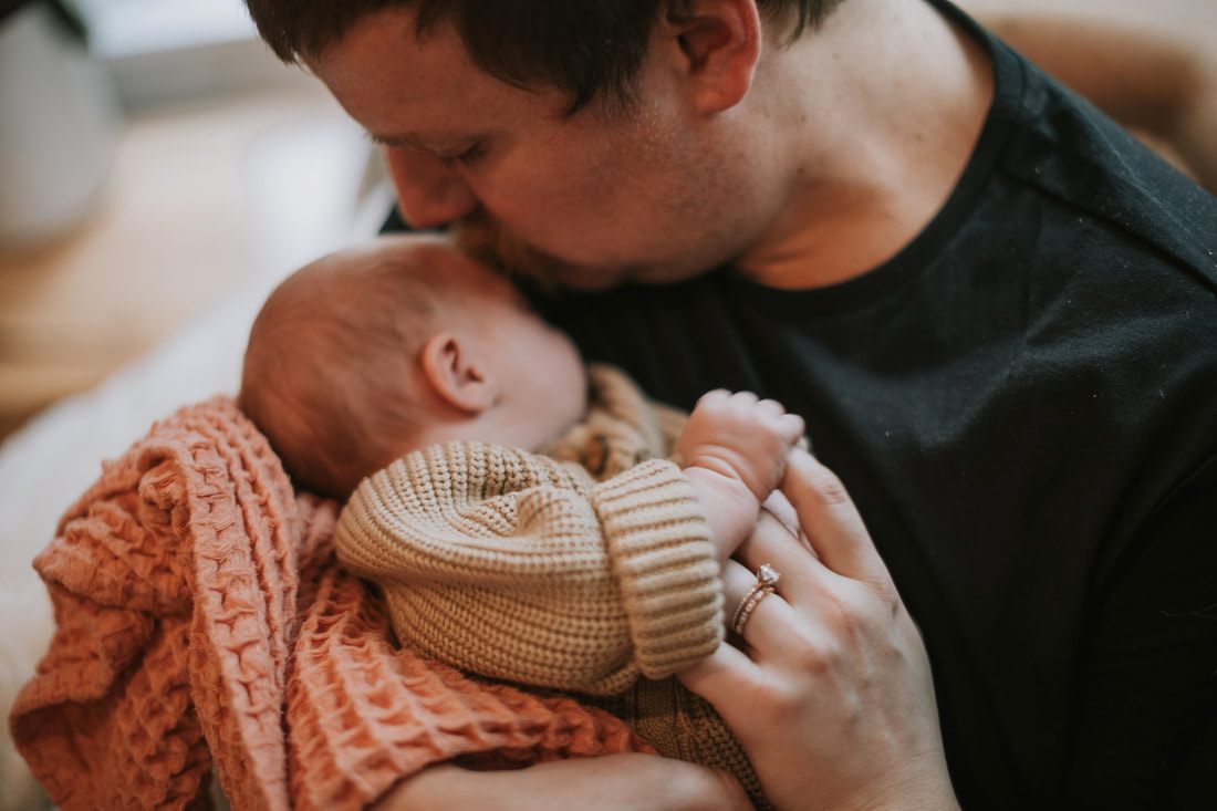 Close-up of a newborn baby's tiny hand resting on a blanket